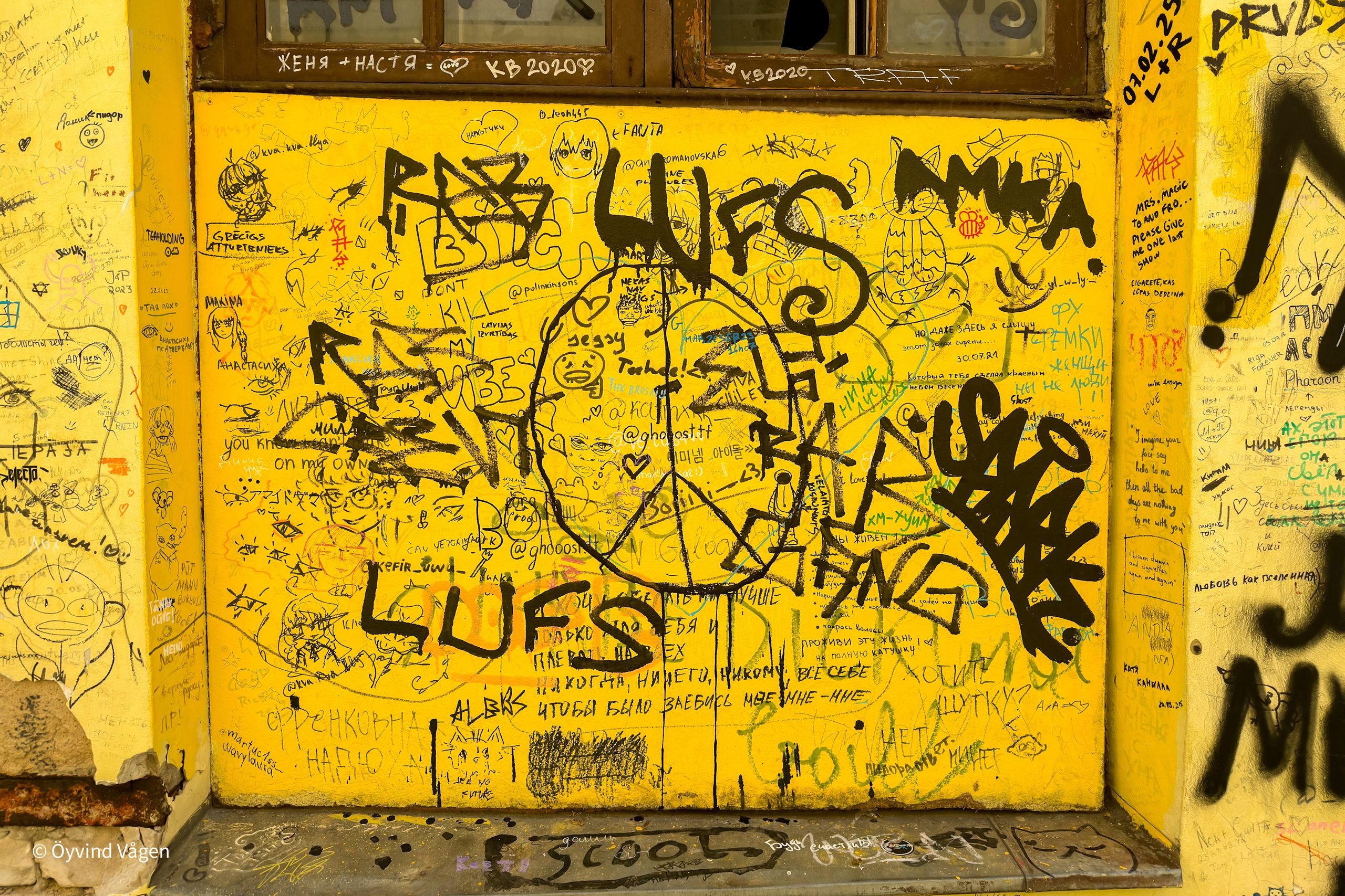 Gul vägg med graffiti och klotter