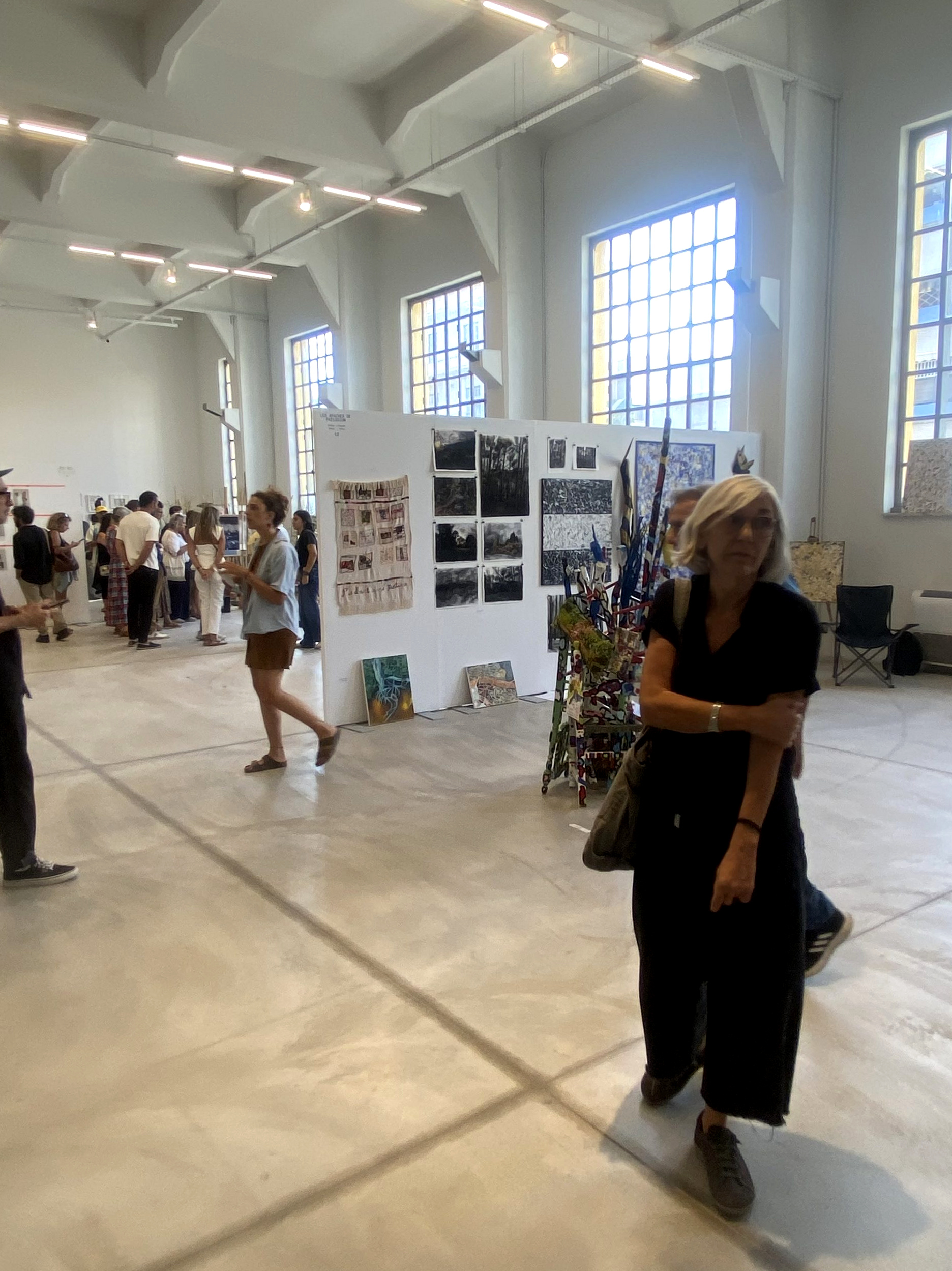 Besökare bland konstverken i en ljus utställningssal på Platforms Project.