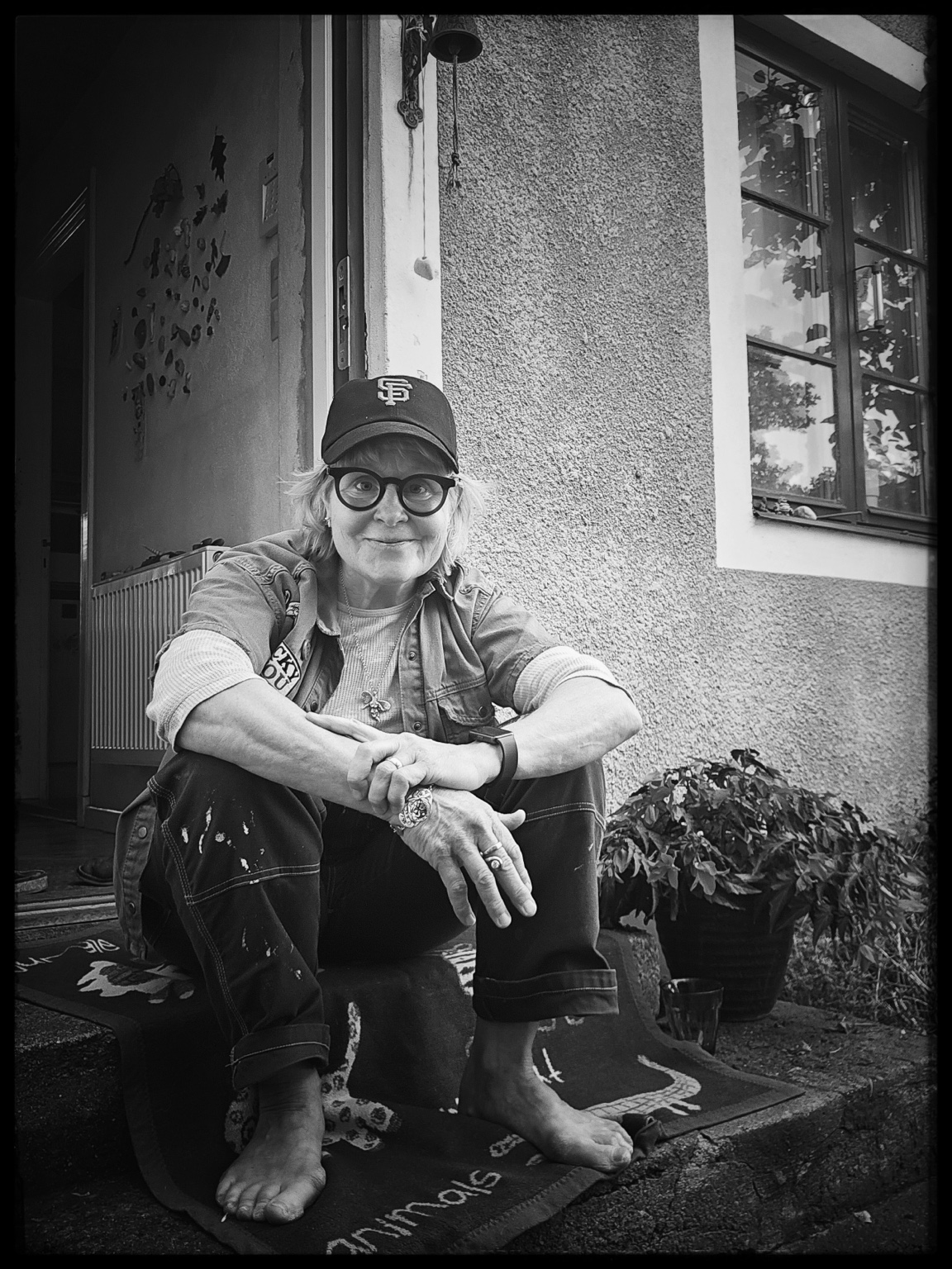 Anna Celander sitter på en trappa utanför ett hus.