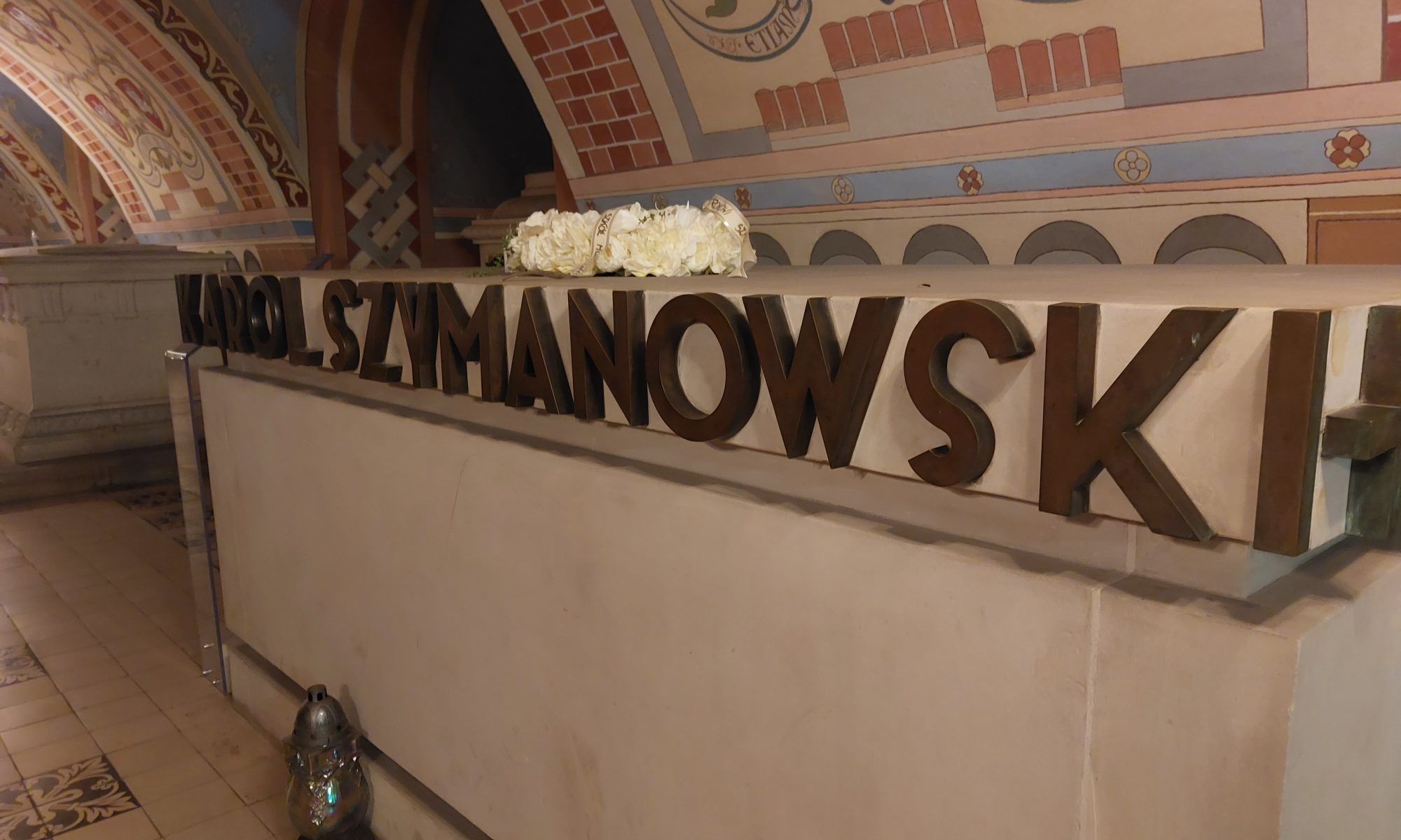 Karol Szymanowskis grav med hans namn i stora bokstäver och vita blommor, i en krypta med målade valv.
