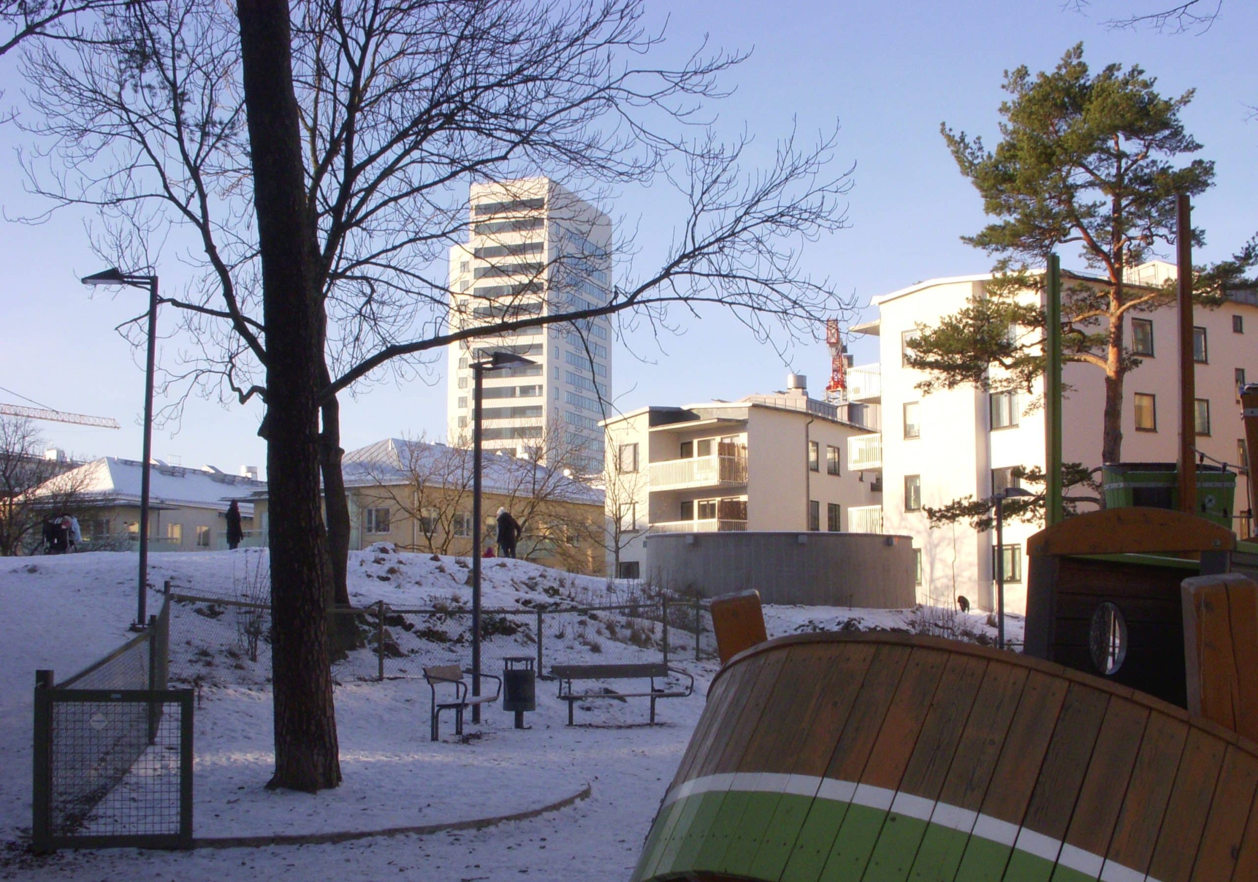Nelly Sachs park på Kungsholmen, med snö på marken och träd framför bostadshusen.