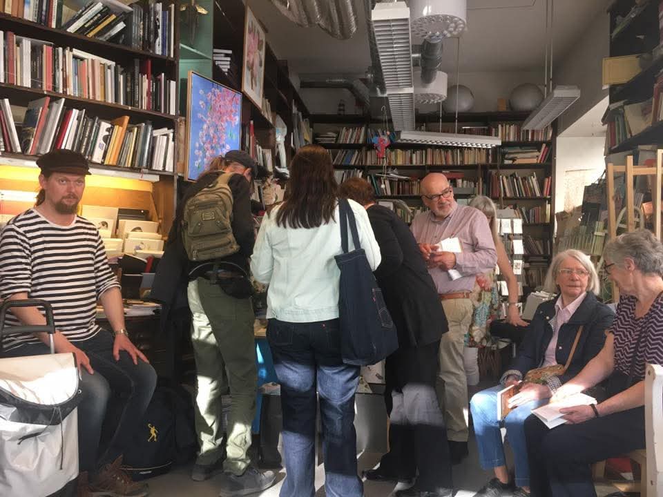 Deltagare samlade bland bokhyllor vid releasefesten för Tisdagspoeternas antologi 2018.